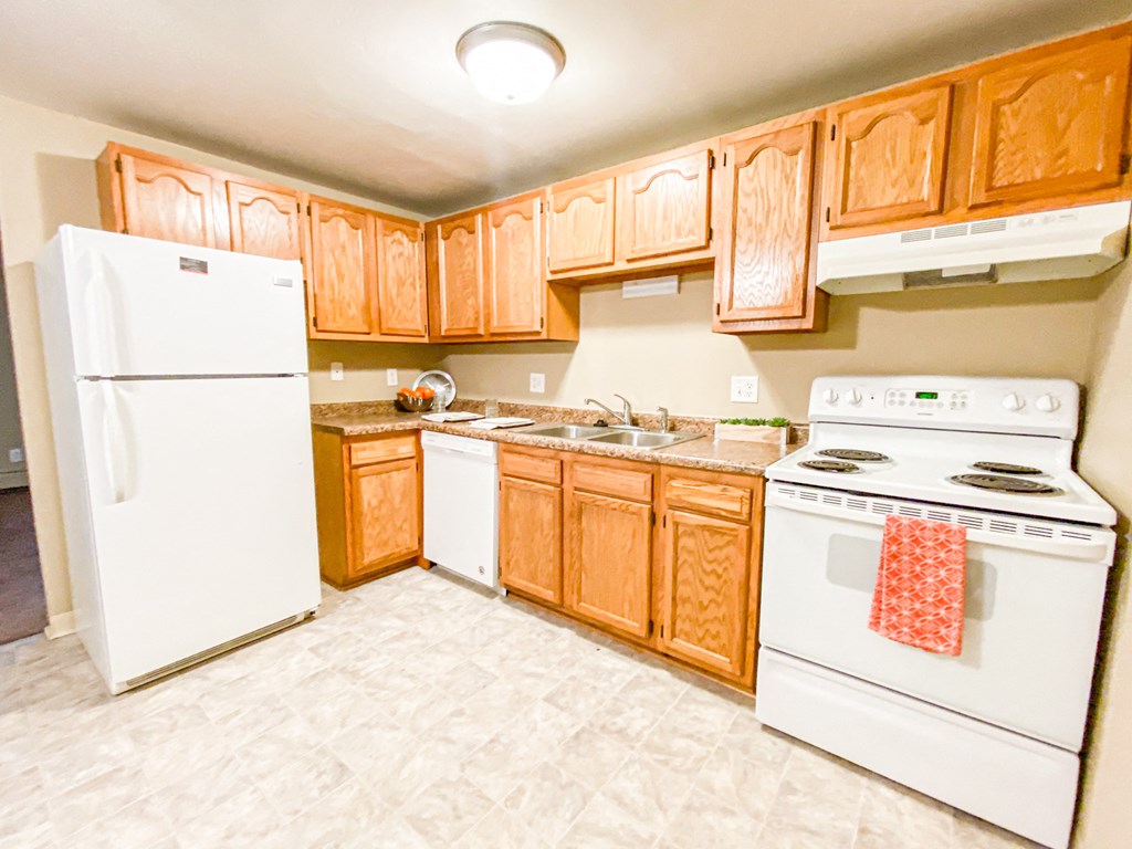 a kitchen with white appliances and wooden cabinets