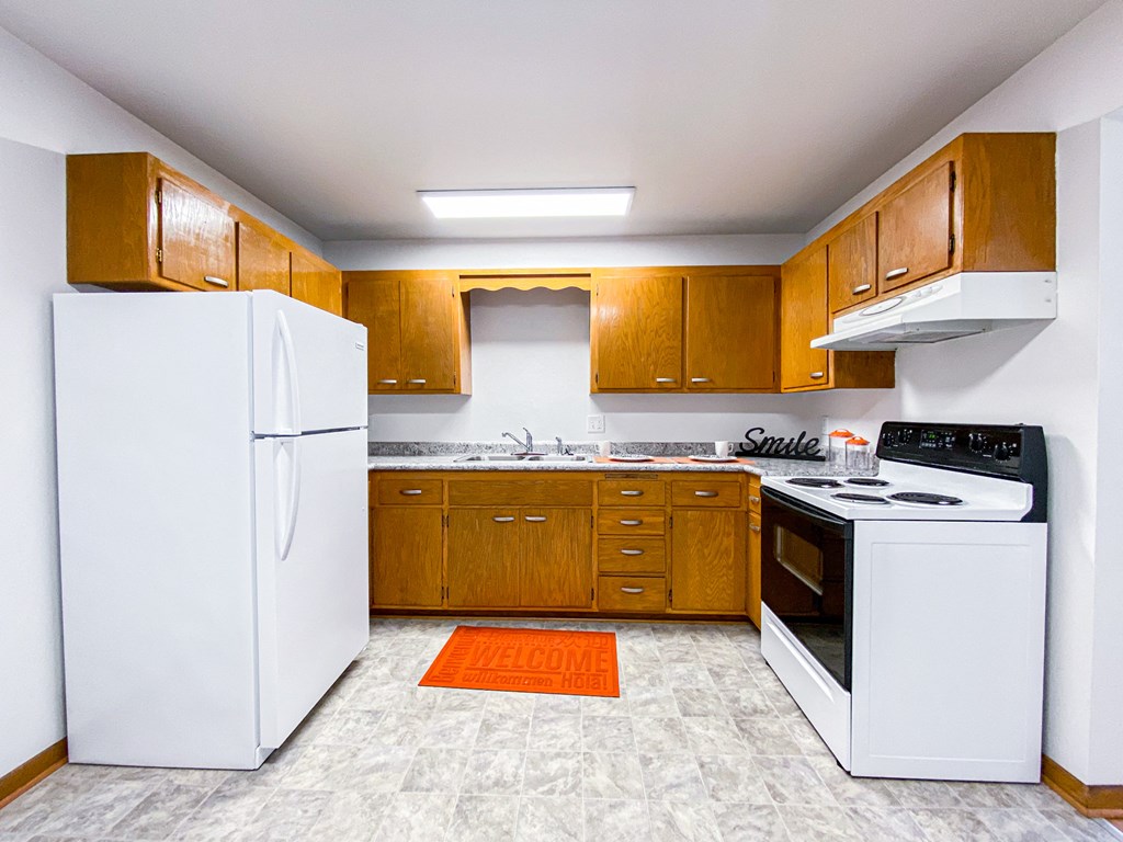 a kitchen with white appliances and wooden cabinets