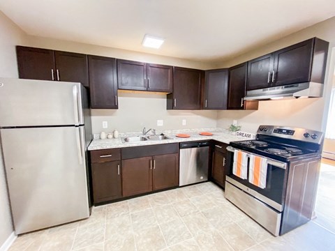 a kitchen with stainless steel appliances and dark cabinets