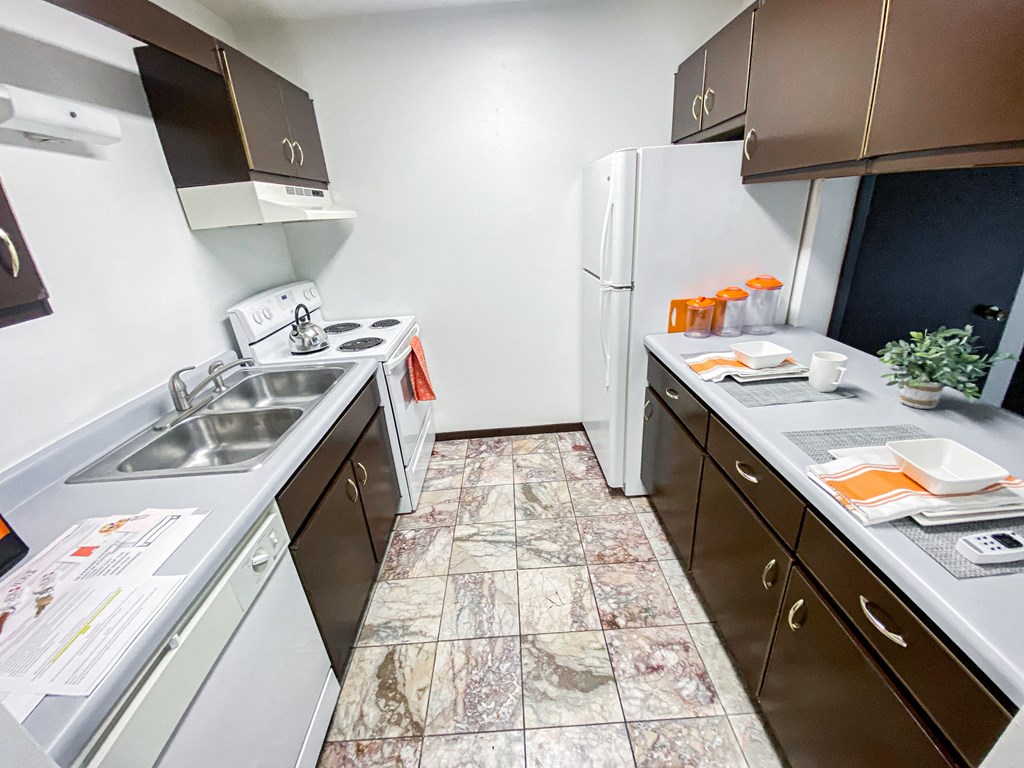 an empty kitchen with a sink and a refrigerator