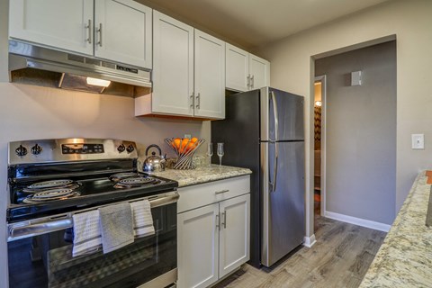 A kitchen with a black stove top oven and a black refrigerator.