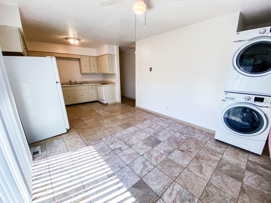 an empty laundry room with a washing machine and a washer and dryer