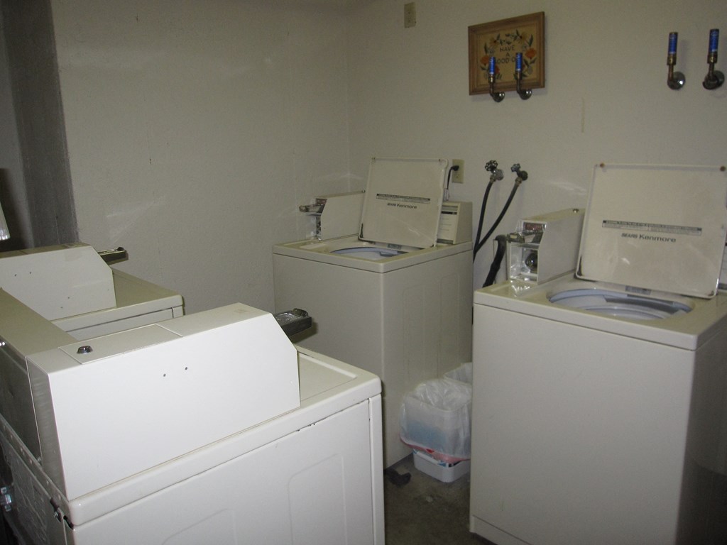 the laundry room has three washers and two dryers