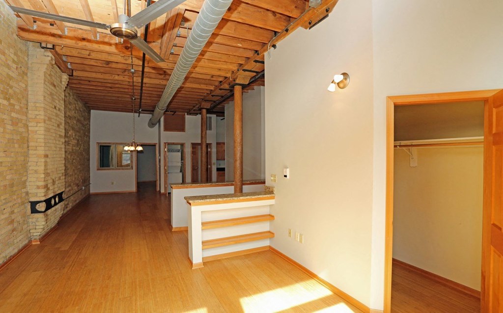 a large living room with a wood floor and exposed ceilings