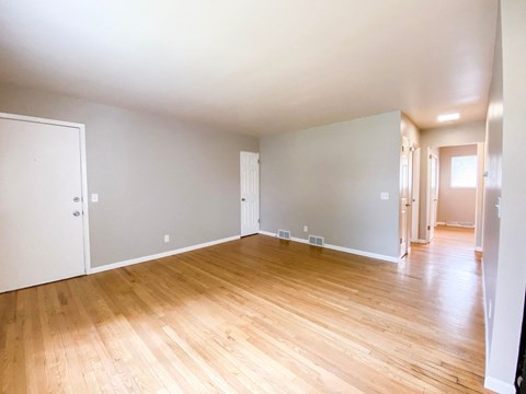 the living room and dining room of an empty house with wood floors