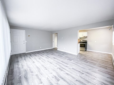A room with a grey wooden floor and white walls.
