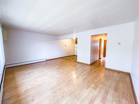 A room with wooden flooring and white walls.