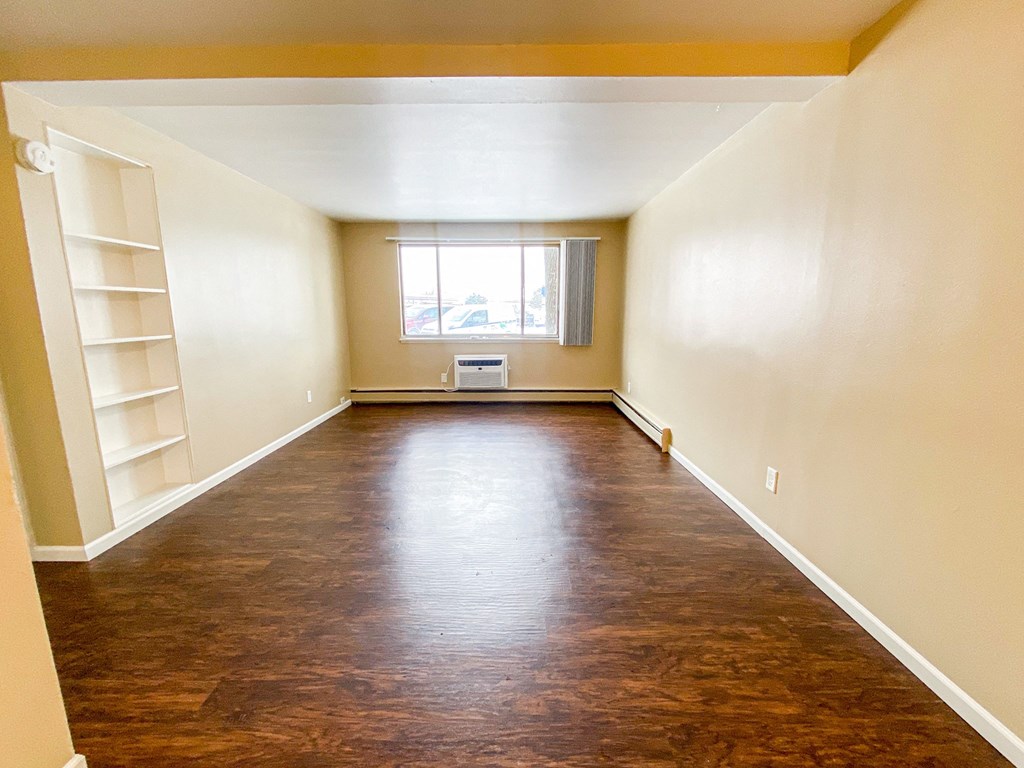a empty room with wood floors and a window
