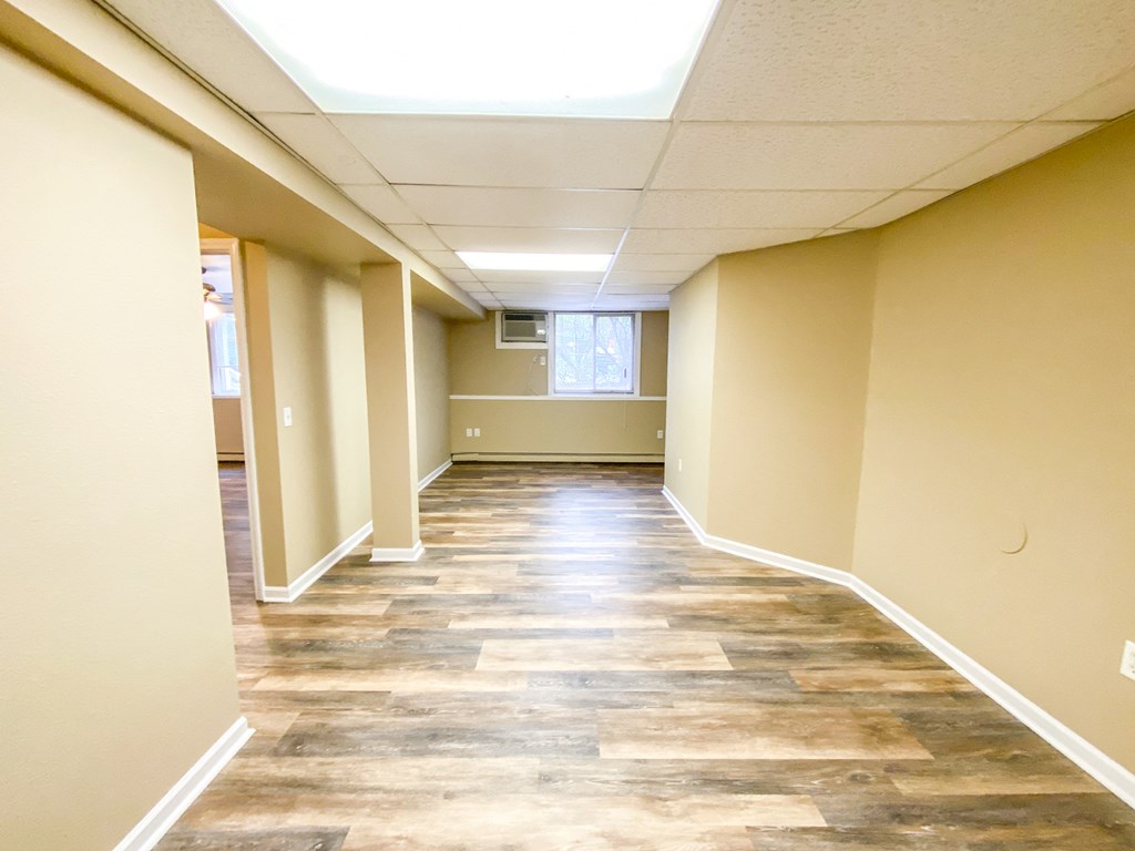 an empty hallway with wood floors and white walls