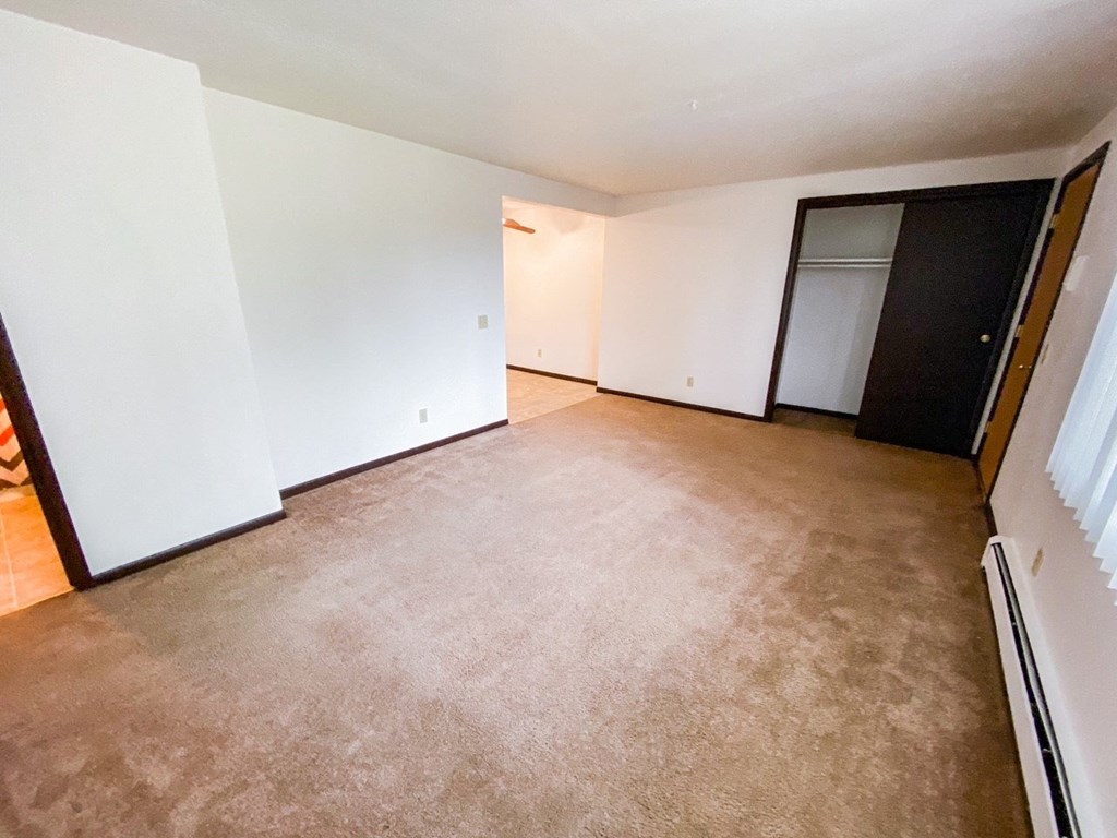 an empty living room with white walls and a carpet