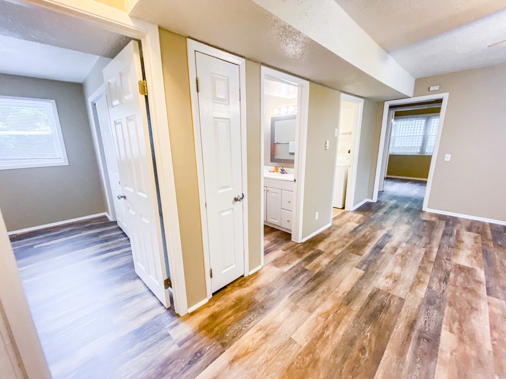an empty living room with wooden floors and white doors