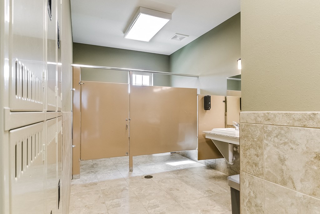 a public bathroom with frosted glass doors