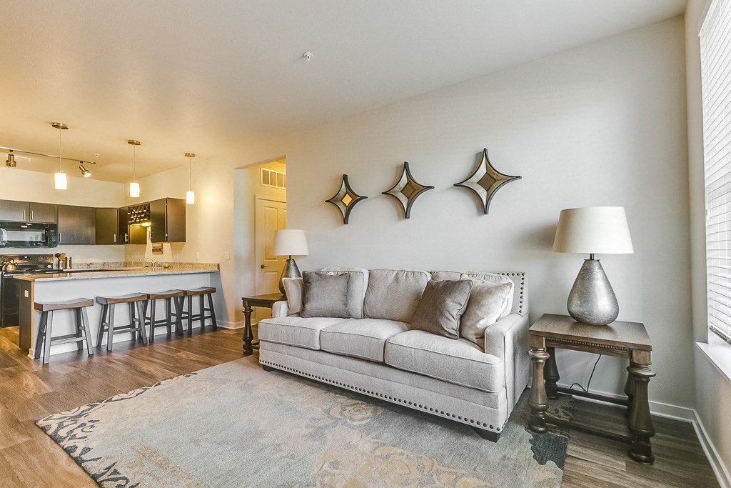 a living room with a couch and a kitchen in the background