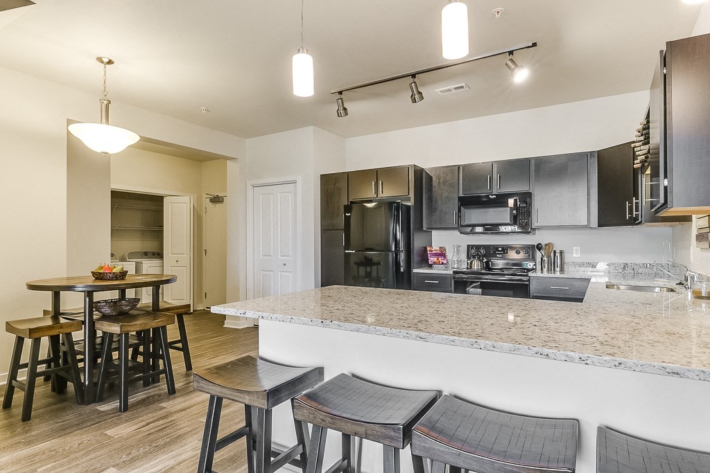 a kitchen with a large island with a breakfast bar and stools