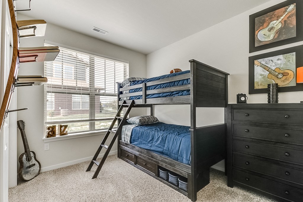 a bedroom with bunk beds and a guitar on the wall