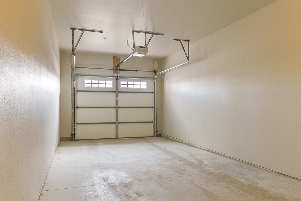 an empty room with white walls and a garage door