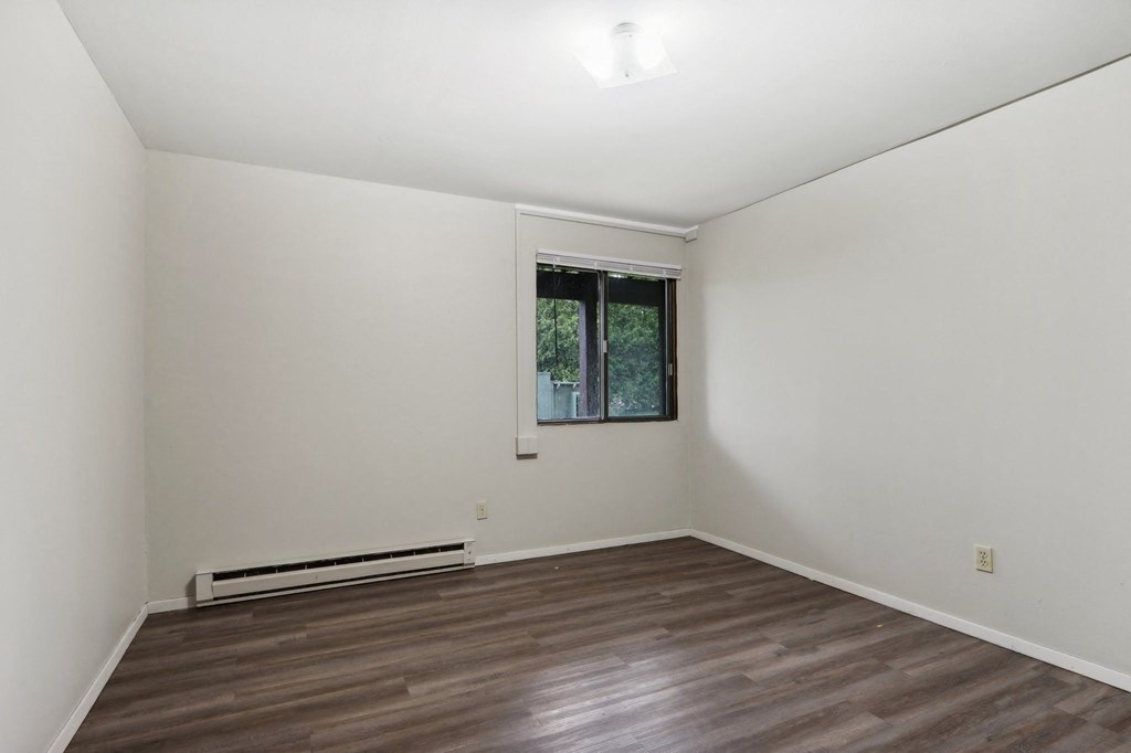 a living room with a window and a wooden floor