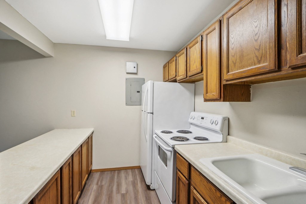 an empty kitchen with a stove refrigerator and sink