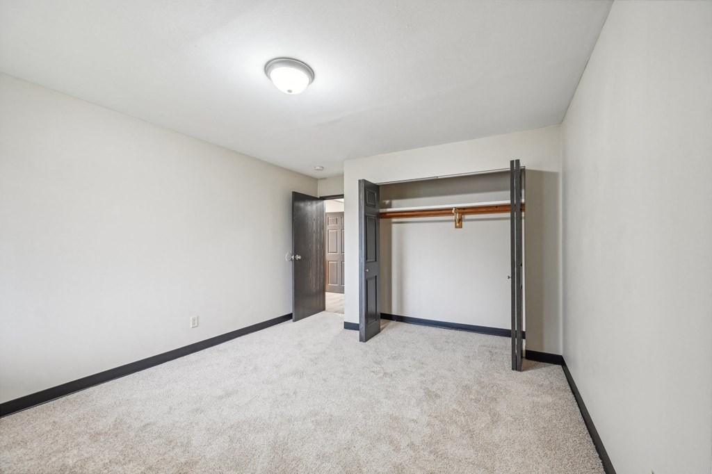a empty room with white walls and a door to a closet