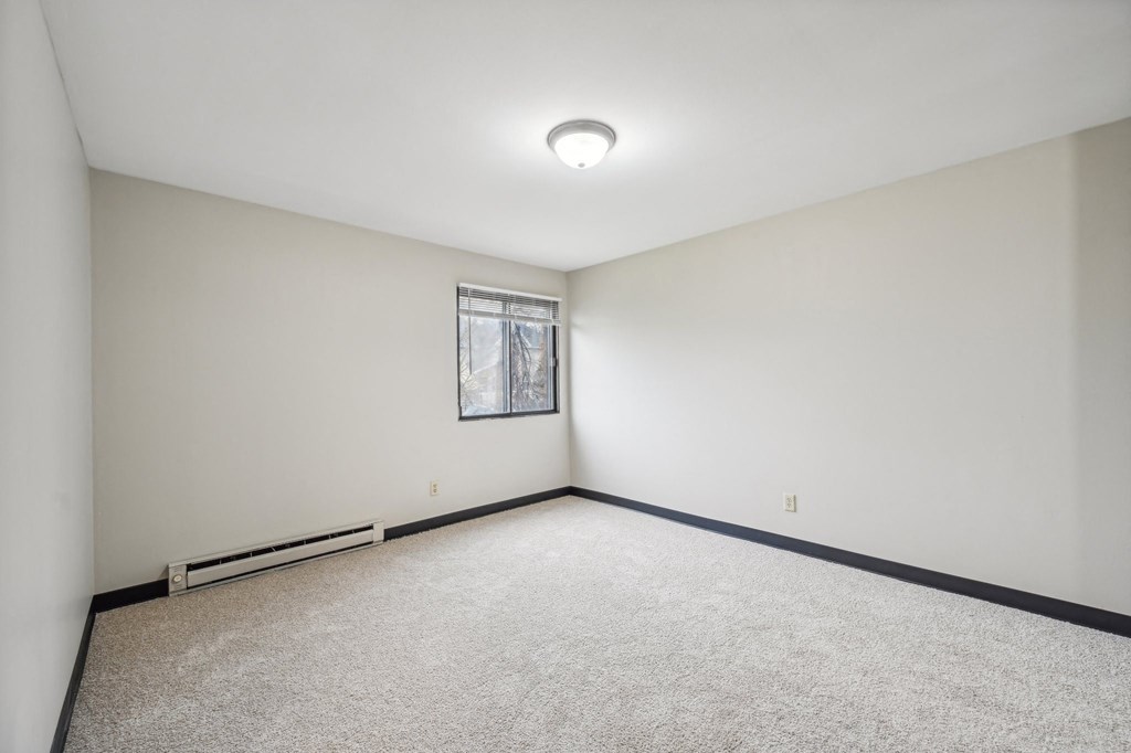 an empty room with white walls and a window