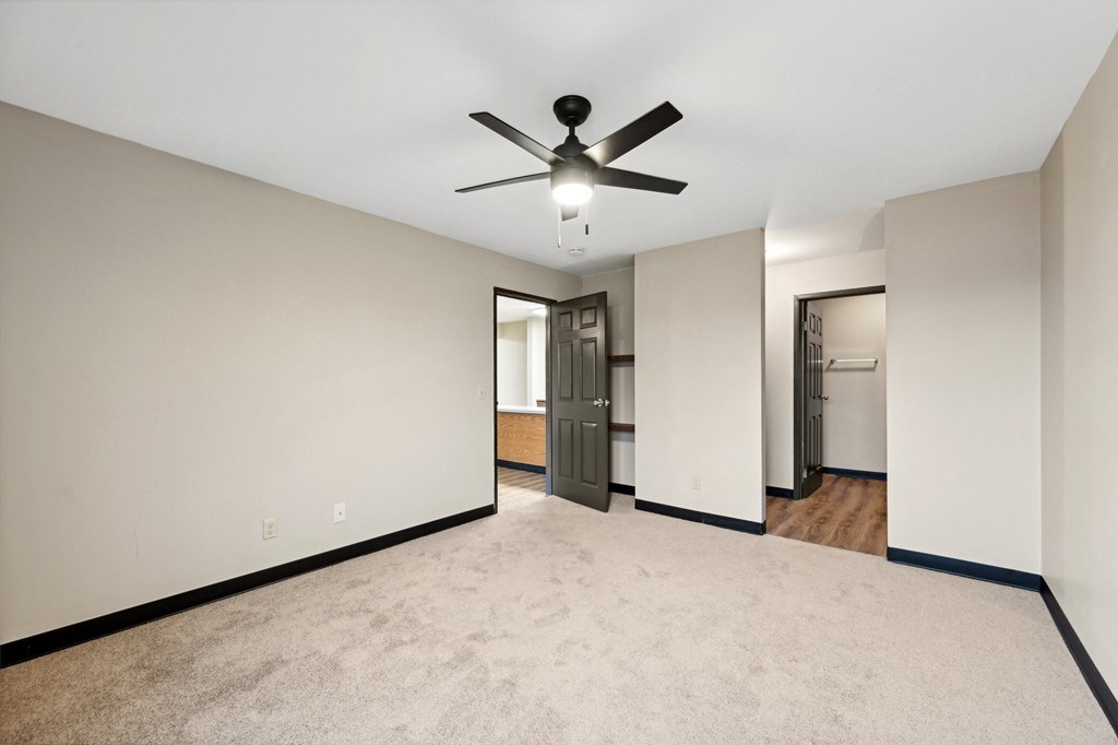 the living room is empty and has a ceiling fan