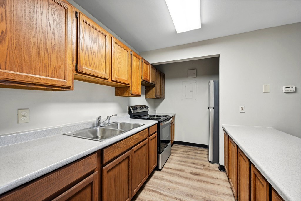 a kitchen with wooden cabinets and a sink and a refrigerator