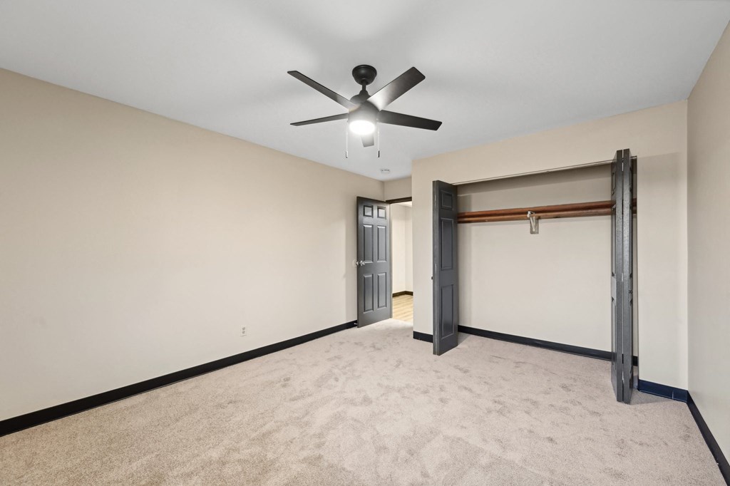 a empty living room with a ceiling fan and a garage door