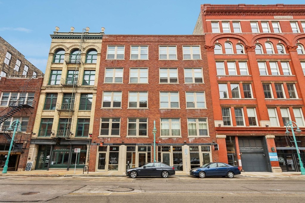 a large brick building with three cars parked in front of it