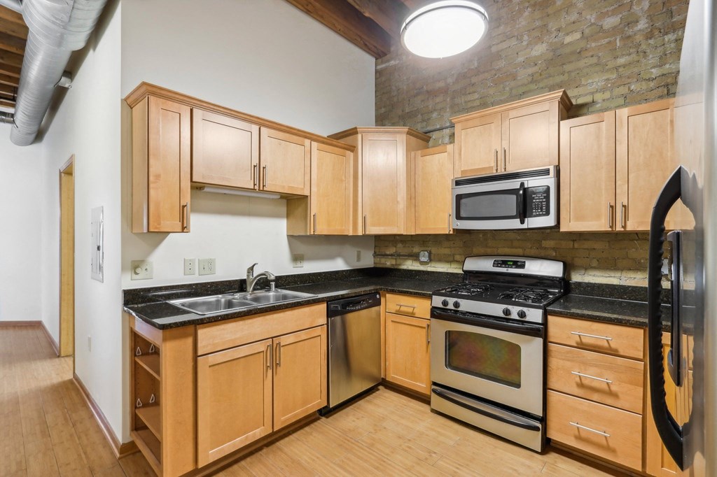a kitchen with wooden cabinets and stainless steel appliances