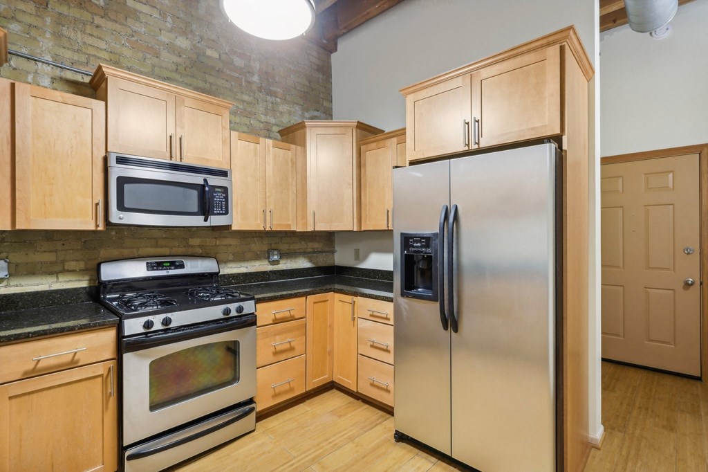 a kitchen with wooden cabinets and stainless steel appliances