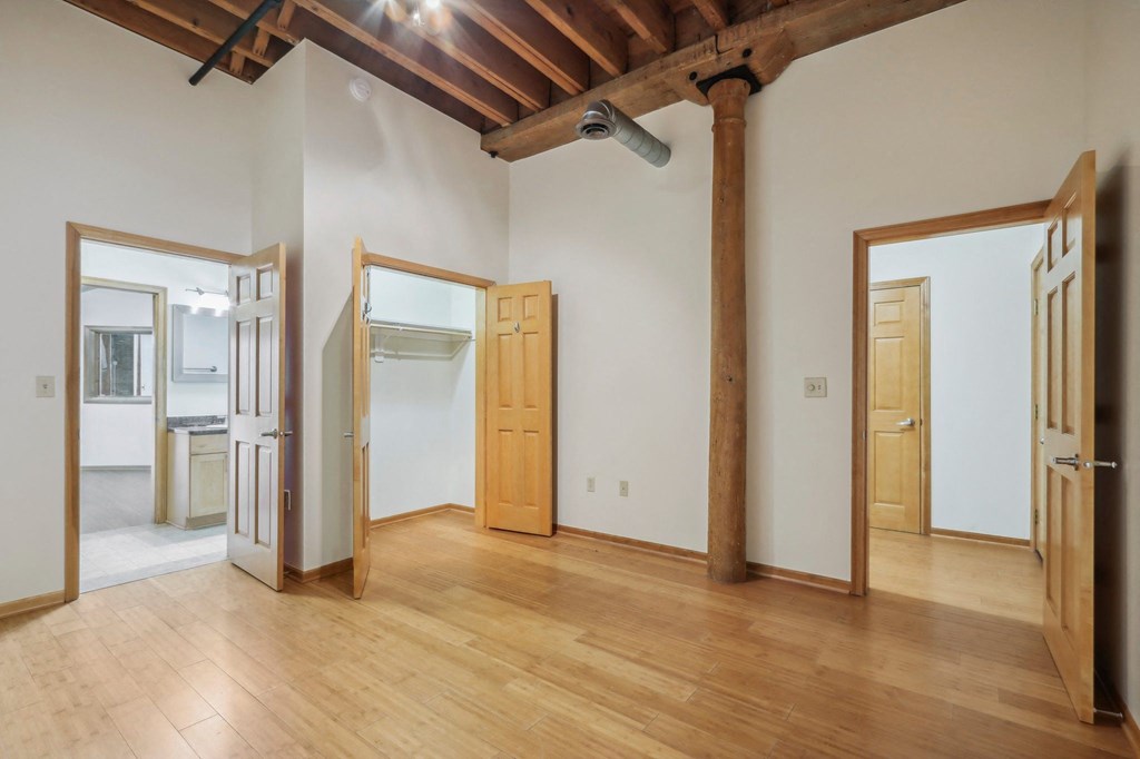 an empty living room with wood floors and white walls
