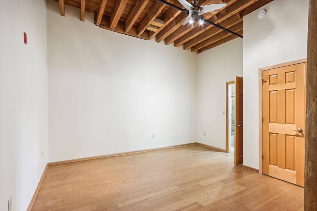 an empty room with wooden floors and a wooden door