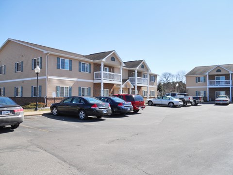 A parking lot with cars and apartment buildings in the background.