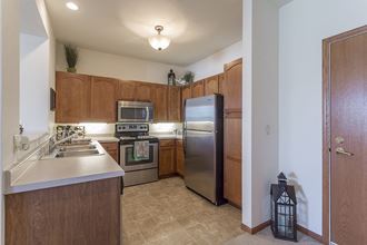 a kitchen with stainless steel appliances and wooden cabinets