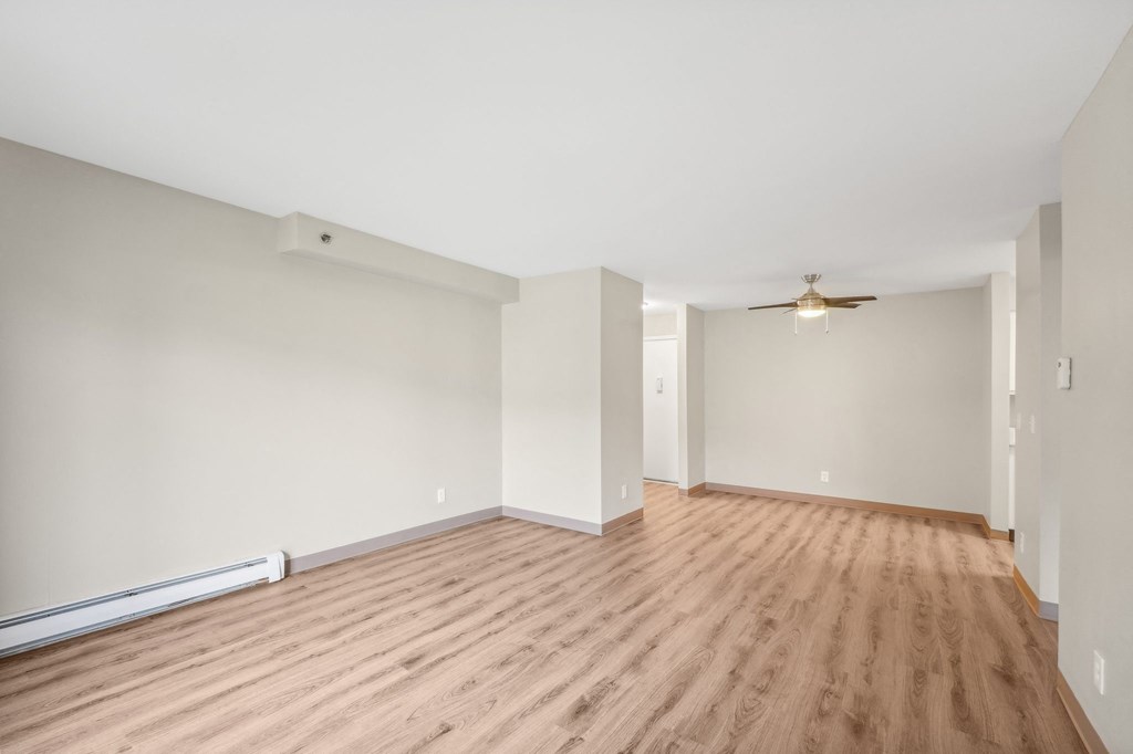 a living room with a hard wood floor and white walls