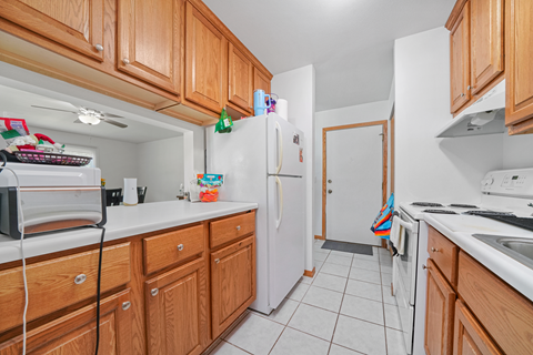 A kitchen with wooden cabinets and white appliances.