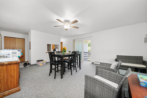 A living room with a dining table and chairs.