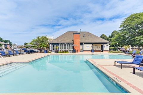 A large swimming pool with a building in the background.