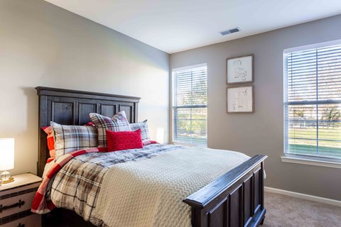 A bedroom with a bed, nightstand, and window.