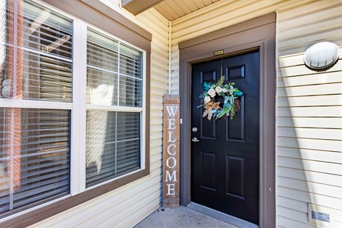 A black door with a wreath and a sign that says