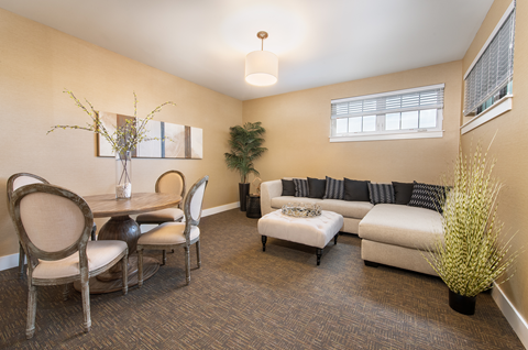 A living room with a dining table and chairs.