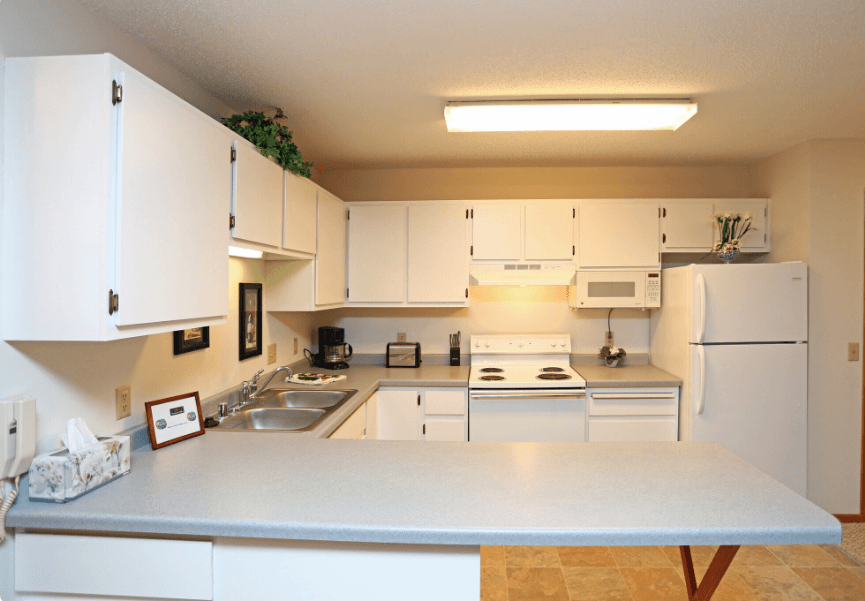 A kitchen with white cabinets and appliances.