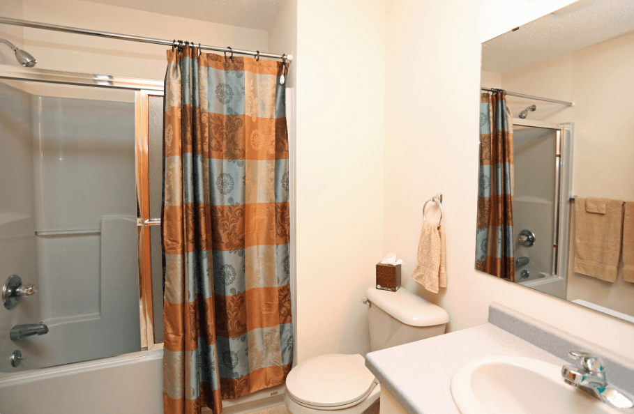 A bathroom with a toilet, sink, and shower.