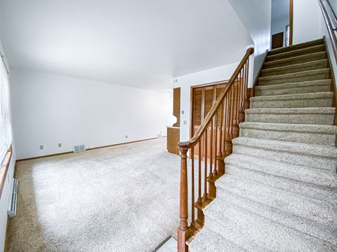 a view of a staircase in a house with a carpeted floor and white walls