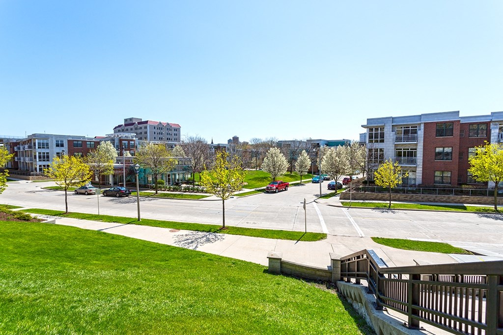 a view of a parking lot with green grass and buildings