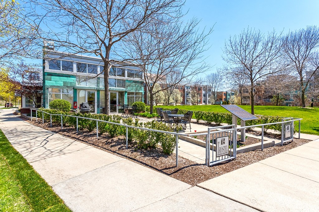 the front of a house with a garden and a sidewalk