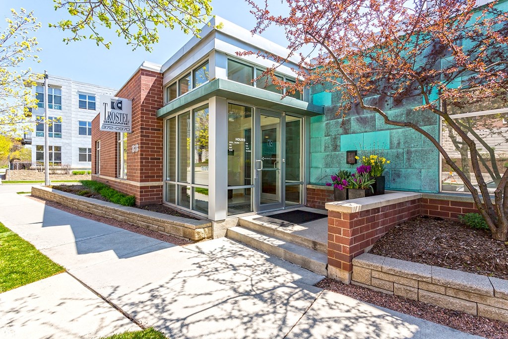 the front entrance of an apartment building with stairs and a sidewalk