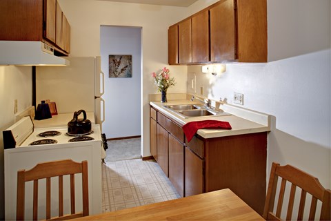 A kitchen with wooden cabinets and a white refrigerator.