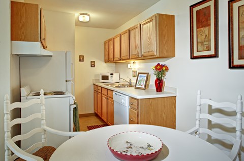 A white table with a plate on it in a kitchen.
