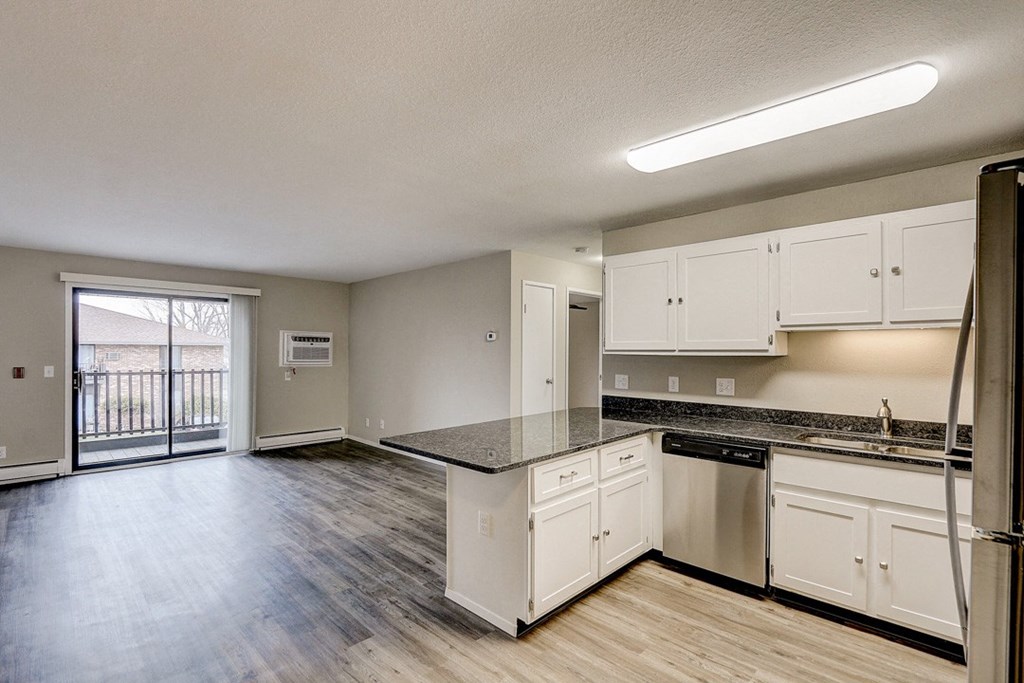 an empty kitchen with white cabinets and stainless steel appliances